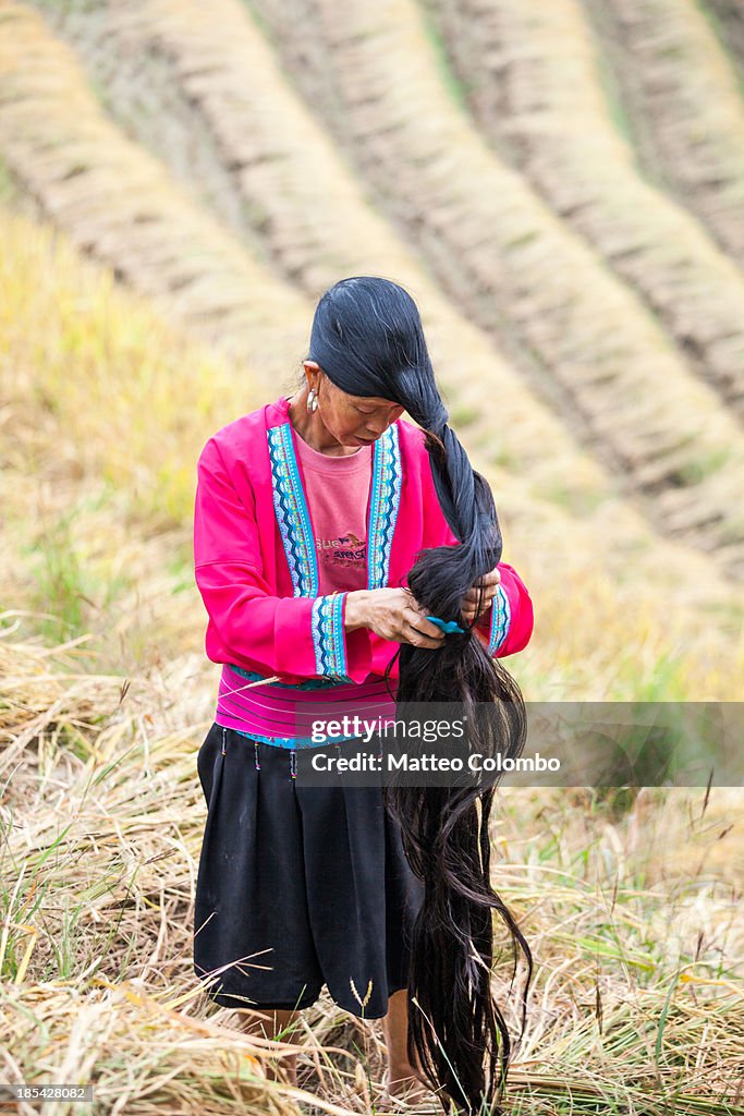 Yao minority woman showing her long hair, China