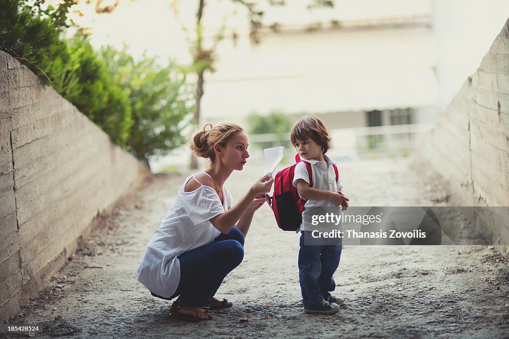 Mother preparing her kid for school