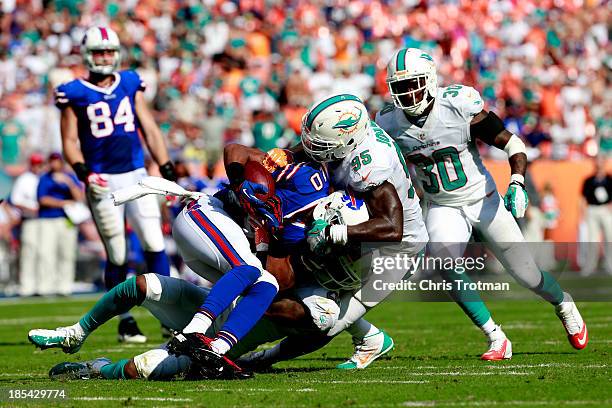 Robert Woods of the Buffalo Bills is tackled by Reshad Jones of the Miami Dolphins and Dion Jordan of the Miami Dolphins at Sun Life Stadium on...