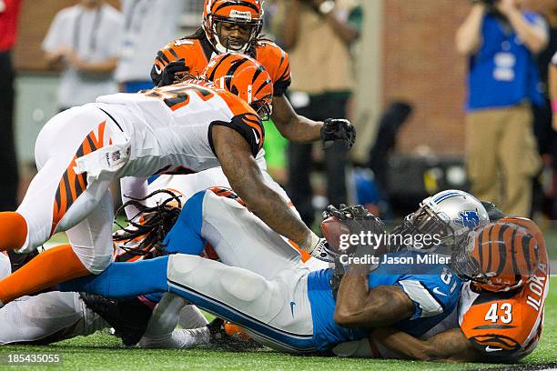 Wide receiver Calvin Johnson of the Detroit Lions catches a touchdown pass as he's tackled by strong safety George Iloka of the Cincinnati Bengals...