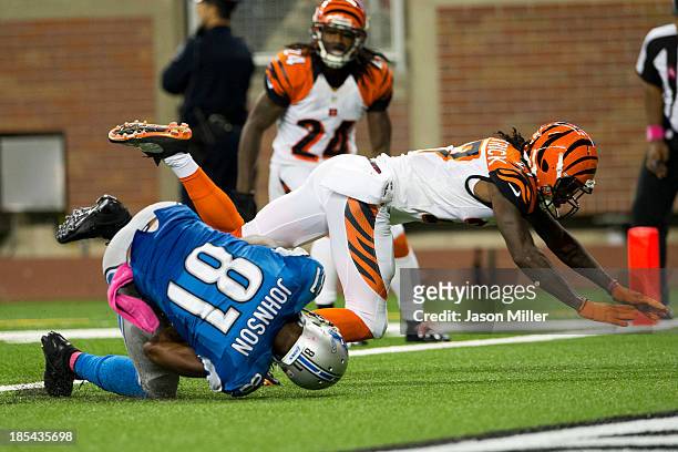 Cornerback Dre Kirkpatrick of the Cincinnati Bengals tackles wide receiver Calvin Johnson of the Detroit Lions as Johnson lands in the end zone for a...