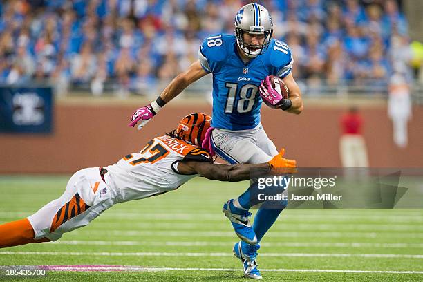 Cornerback Dre Kirkpatrick of the Cincinnati Bengals tackles wide receiver Kris Durham of the Detroit Lions during the first half at Ford Field on...