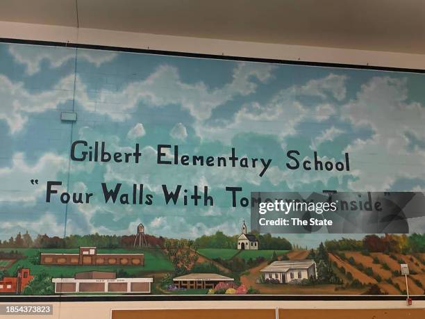 Inside of the cafetorium of the old Gilbert Elementary School is a mural with a saying for students "Four Walls with Tomorrow Inside." The school is...