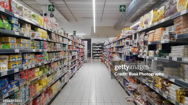 supermarket aisle with merchandise and no people - supermercado fotografías e imágenes de stock