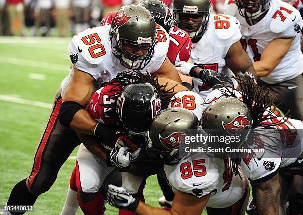 Jacquizz Rodgers of the Atlanta Falcons is tackled by Daniel Te'o-Nesheim, Gary Gibson, and Mark Barron of the Tampa Bay Buccaneers at the Georgia...