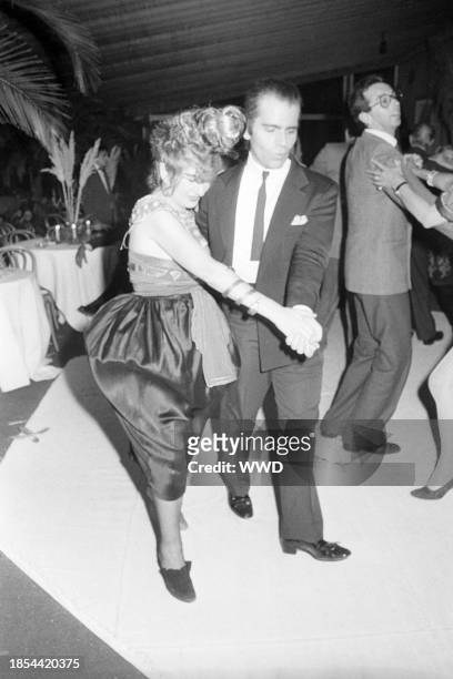 Fashion designer Karl Lagerfeld dancing with his pal Anna Piaggi, in her Sonia Delauna Cleopatra look, complete with one black and one red shoe, both...