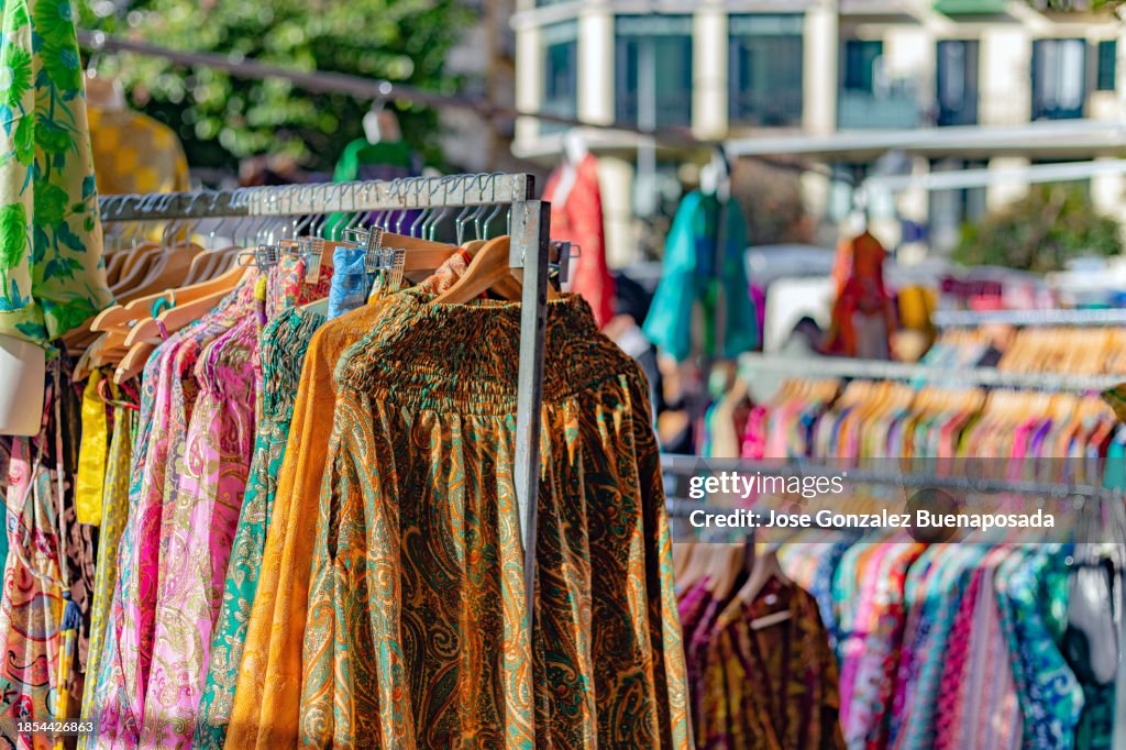 Colorful dresses on hangers at a street stall in El Rastro flea market in Madrid.