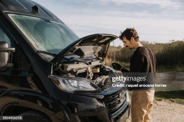 adult man trying to fix a breakdown in his van - torres stock pictures, royalty-free photos & images