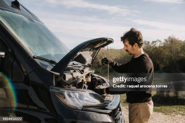 adult man trying to fix a breakdown in his van - vehicle breakdown stock pictures, royalty-free photos & images
