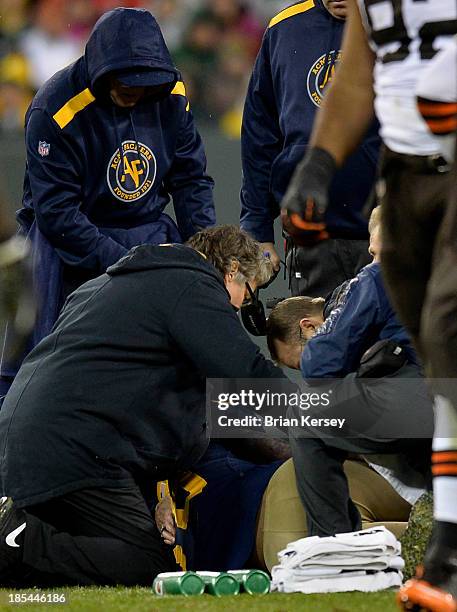 Trainers attend to tight end Jermichael Finley of the Green Bay Packers after he was injured by Tashaun Gipson of the Cleveland Browns during the...