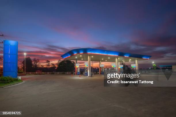 gas station at sunset.horizontal shot of a retail gasoline station and convenience store at dusk. - opec stock pictures, royalty-free photos & images