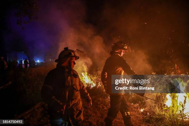 Rural Fire Service firefighters do a back burning during bush fire at West Wallsend on December 14, 2023 in Newcastle, Australia. Several fast-moving...