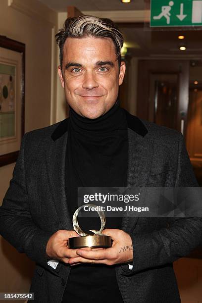 Robbie Williams poses with his Q Icon Award in the press room at The Q Awards 2013 at Grosvenor House on October 21, 2013 in London, England.