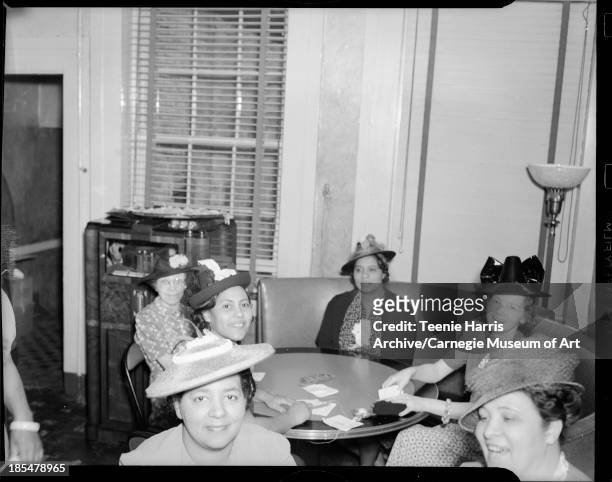 Women, seated in rounded banquette and playing bridge card game in Loendi Club, Pittsburgh, Pennsylvania, April 1939. Including Agnes Stevenson,...
