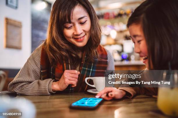 mom & daughter making order from the digital menu app on smart phone in restaurant - family ordering at restaurant stock pictures, royalty-free photos & images