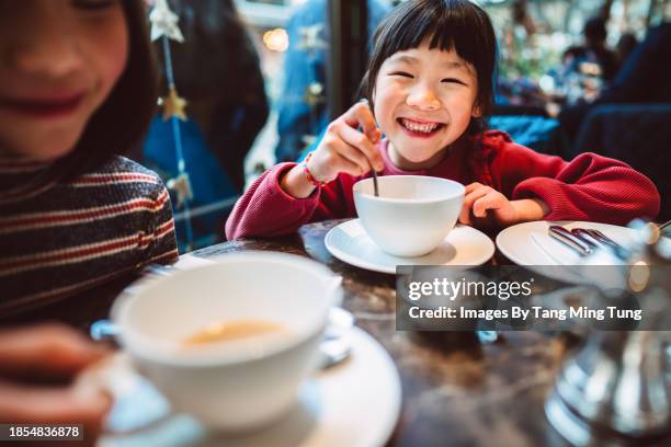 lovely cheerful girl enjoying traditional afternoon tea with her family in restaurant - tea shop stock pictures, royalty-free photos & images