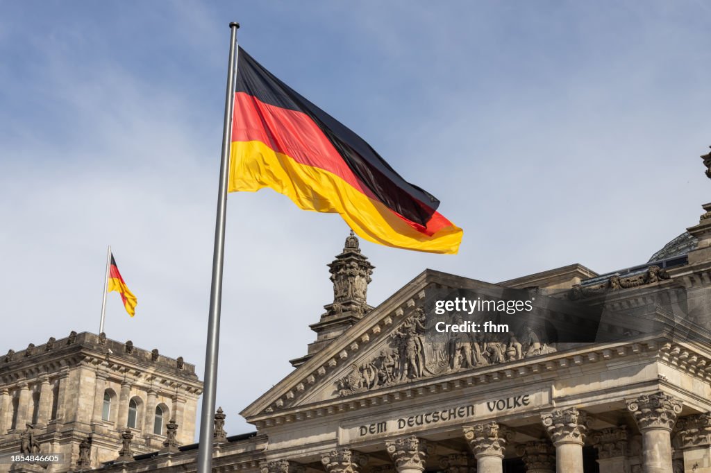 Deutscher Bundestag - Reichstag building with German flags (German parliament building) - Berlin, Germany