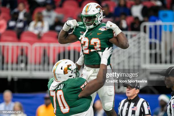 Running back Terrell Jennings flexes his muscles after being lifted into the air by teammate offensive lineman KJ McCou during the Cricket...