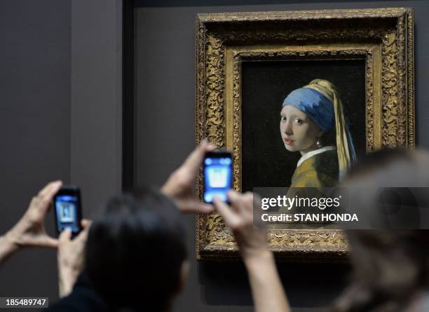 People view "Girl with a Pearl Earring " by Johannes Vermeer in the exhibition "Vermeer, Rembrandt, and Hals: Masterpieces of Dutch Painting from the...