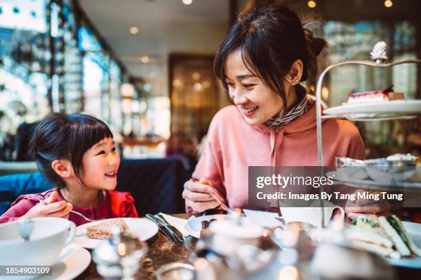 mom & daughter enjoying traditional afternoon tea together in a restaurant - tea shop stock pictures, royalty-free photos & images