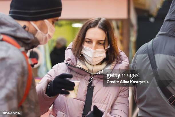 people in medical masks want to drink coffee at a christmas trade fair - coronavirus ward stock pictures, royalty-free photos & images