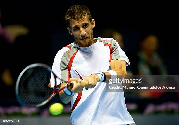 Martin Klizan of Slovakia plays a backhand in his Men's Singles match against Fabio Fognini of Italy during day one of the Valencia Open 500 at the...