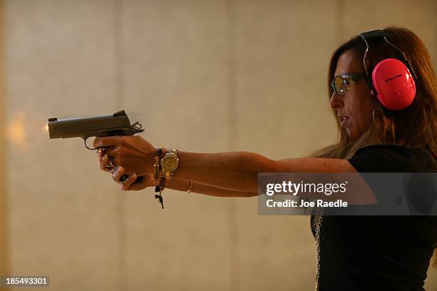 Susan Kushlin shoots a pistol while wearing one of the bracelets that her company, Gun Girls, Inc., created for women that enjoy guns on October 21,...