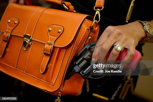 Susan Kushlin poses with a concealed-carry handbag that her company, Gun Girls, Inc., created for women that enjoy guns on October 21, 2013 in Boca...