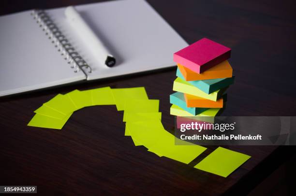 close-up of question mark of sticky notes with notebook and multi colored sticky notes for organizing and productivity - nathalie pellenkoft stock pictures, royalty-free photos & images