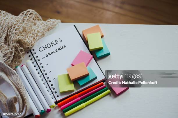 high angle view of notebook with multi colored sticky notes on white table for organizing and productivity - nathalie pellenkoft stock pictures, royalty-free photos & images