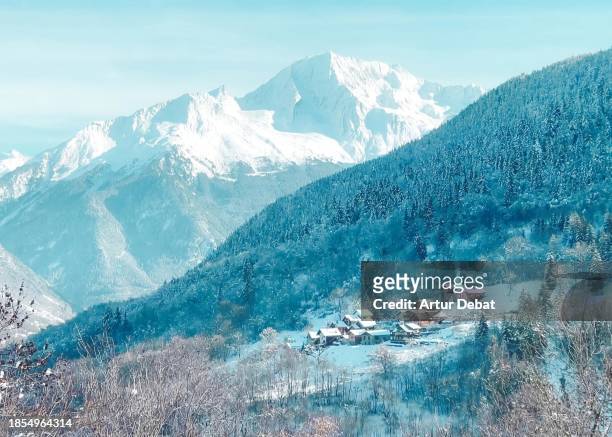 bucolic winter view of the snowy alps with rustic town and peak mountain. - meribel stock pictures, royalty-free photos & images