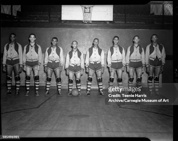 Group portrait of Renaissance 'Rens' basketball team members, in gymnasium with basketball hoop in background, Pittsburgh, Pennsylvania, January 7,...