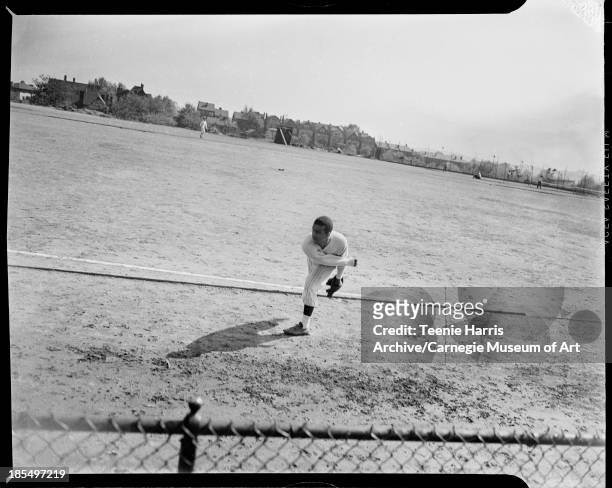 Schenley High School baseball pitcher Fred Campbell throwing ball on fenced field, Pittsburgh, Pennsylvania, May 1941.