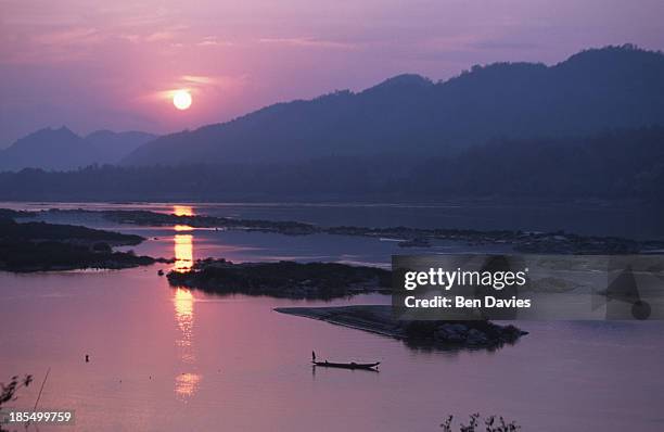 Sunset over a boat on the Mekong River near the Pak Ou Caves, a short distance from Luang Prabang, the former capital of Laos. The Mekong is one of...