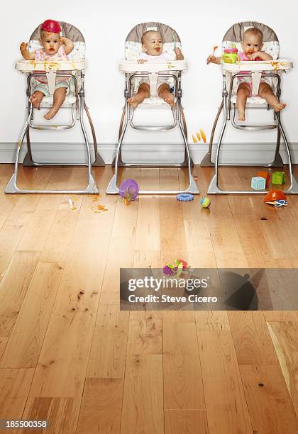 triplets eating in high chairs - triplets stock pictures, royalty-free photos & images