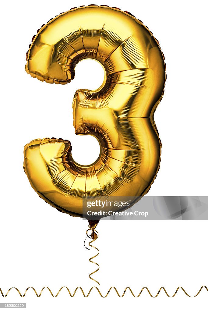 Gold balloon in the shape of a number three