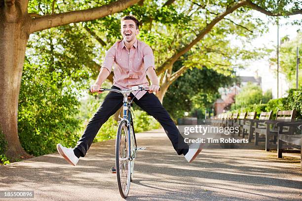 man with legs in air on bike - poise stock pictures, royalty-free photos & images