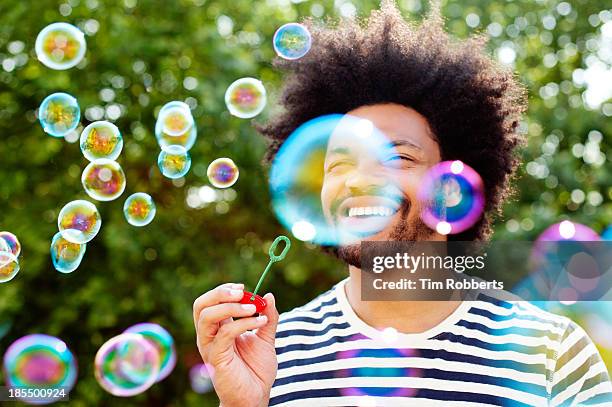 man blowing bubbles. - blowing bubbles foto e immagini stock