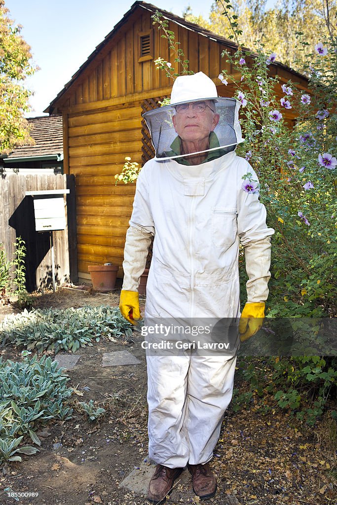 Beekeeper standing by his bee hive