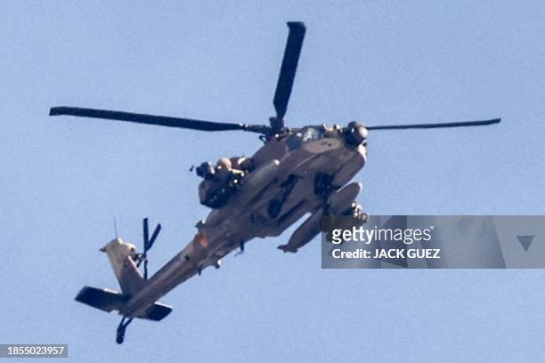 An Israeli air force attack helicopter flies over the northern Gaza Strip near the border with southern Israel on December 17, 2023 amid continuing...