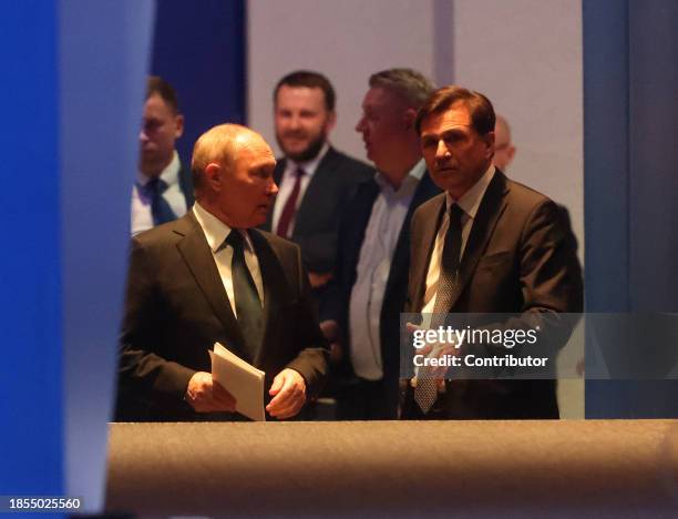 Russian President Vladimir Putin listens to his assisitant Yuri Grechko as he prepares to enter the scene during the 21th Congress of the United...