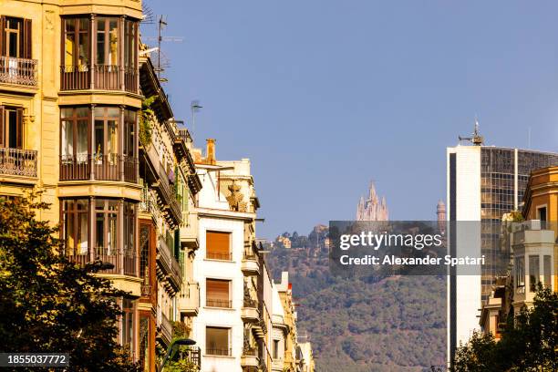 street in barcelona with sagrat cor and tibidabo mountain in the distance, catalonia, spain - sagrat cor stockfoto's en -beelden