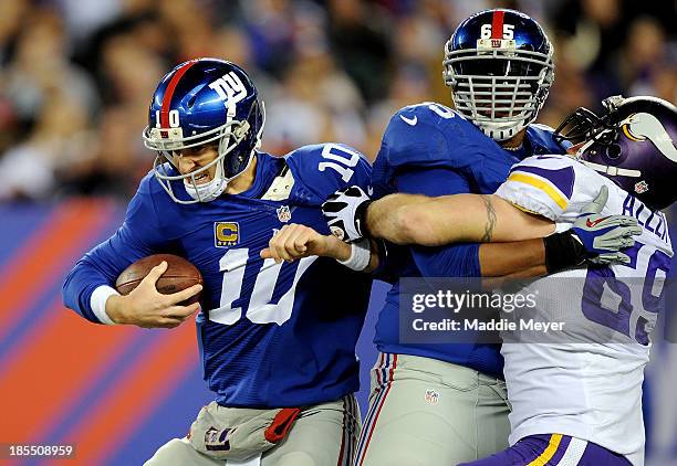 Quarterback Eli Manning of the New York Giants is pressured by defensive end Jared Allen of the Minnesota Vikings during a game at MetLife Stadium on...