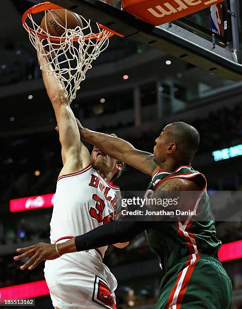 Mike Dunleavy of the Chicago Bulls is fouled across the face by Caron Butler of the Milwuakee Bucks during a preseason game at the United Center on...