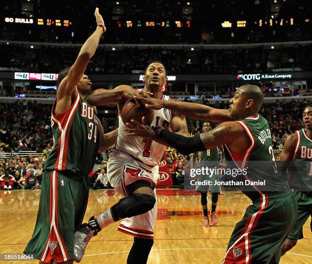 Derrick Rose of the Chicago Bulls is fouled by Caron Butler of the Milwuakee Bucks as he drives past Giannis Antetokounmpo during a preseason game at...