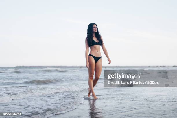 full length of woman walking at beach against sky,corpus christi,texas,united states,usa - corpus christi stock pictures, royalty-free photos & images