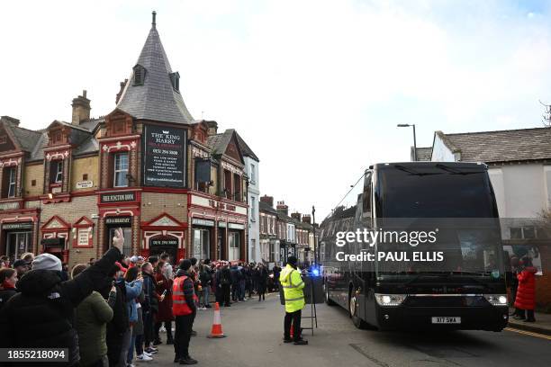 Fans react as the Manchester United team bus arrives ahead of the English Premier League football match between Liverpool and Manchester United at...