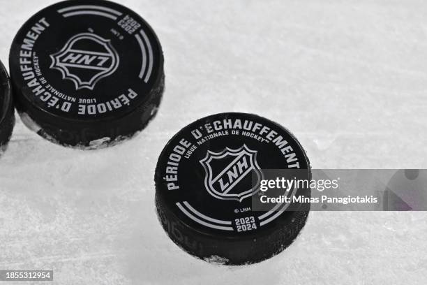 Pucks sit on the ice during warmups prior to the game between the Montreal Canadiens and the Pittsburgh Penguins at the Bell Centre on December 13,...