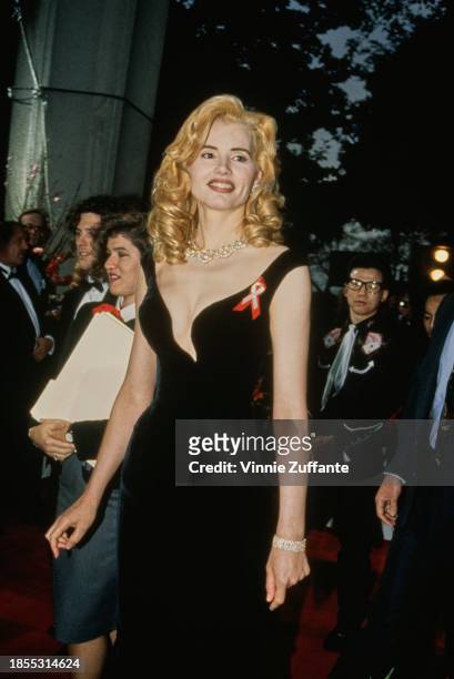 American actress Geena Davis, wearing a black evening gown with a plunging neckline, and an AIDS awareness ribbon, attends the 65th Academy Awards,...