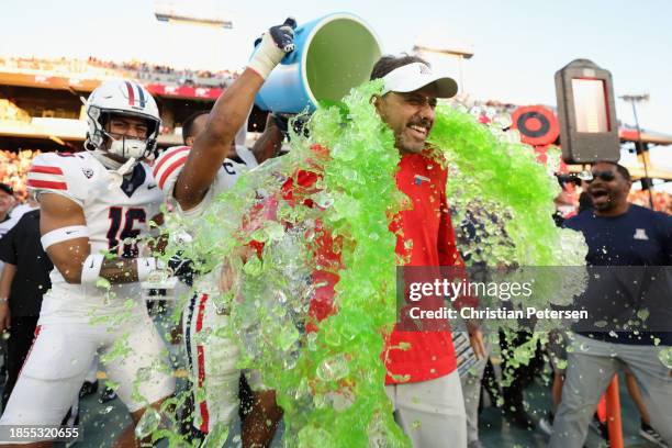 Head coach Jedd Fisch of the Arizona Wildcats is dunked with powerade from Jacob Manu during the final moments of the NCAAF game against the Arizona...